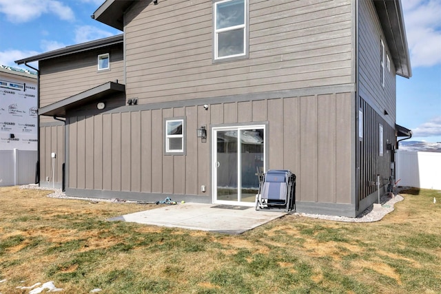 rear view of property featuring a yard, fence, and a patio