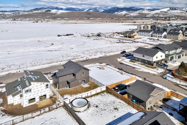 snowy aerial view featuring a residential view and a mountain view