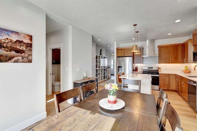 dining area featuring light wood finished floors, baseboards, and recessed lighting