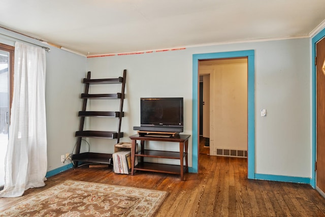 interior space featuring ornamental molding, baseboards, visible vents, and hardwood / wood-style floors