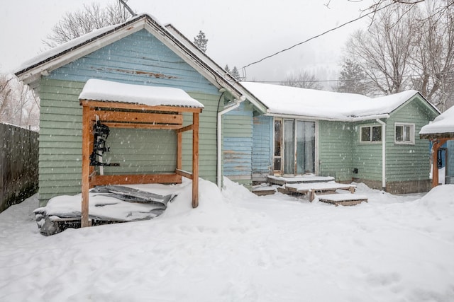 snow covered property with fence