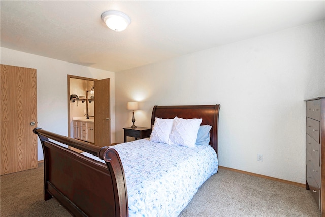 carpeted bedroom with connected bathroom and baseboards