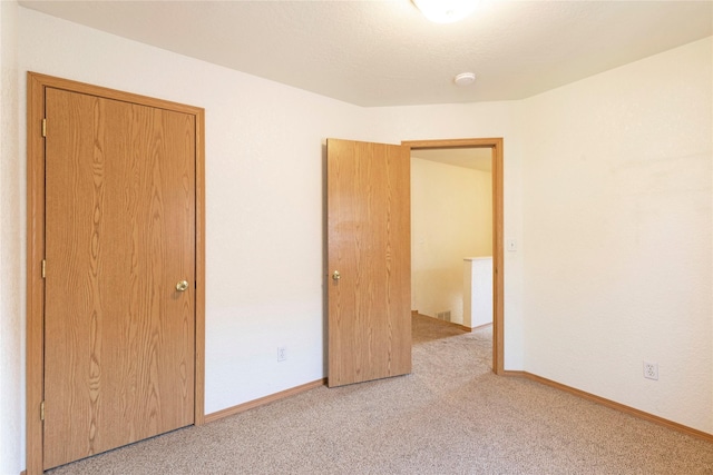 unfurnished bedroom featuring carpet flooring and baseboards