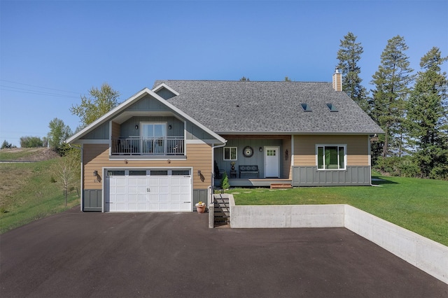 craftsman-style house featuring board and batten siding, a chimney, asphalt driveway, a front lawn, and a garage
