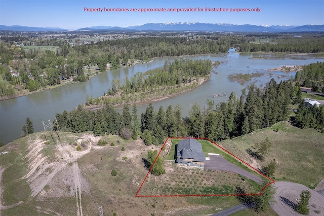 aerial overview of property's location with a heavily wooded area, property boundaries highlighted, and a water and mountain view