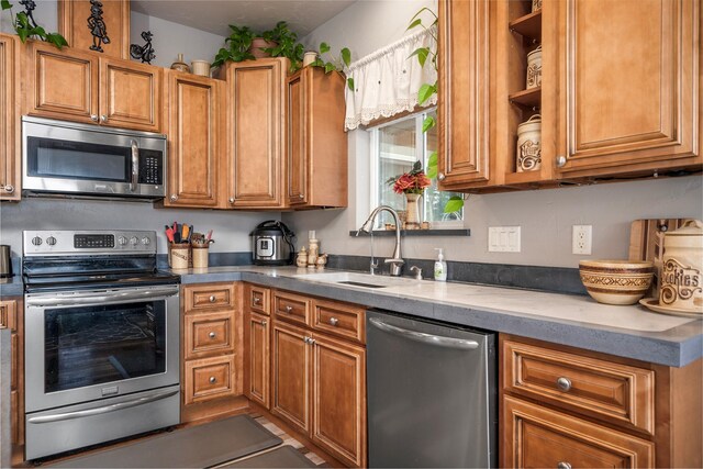 kitchen with stainless steel appliances, brown cabinets, a sink, and open shelves