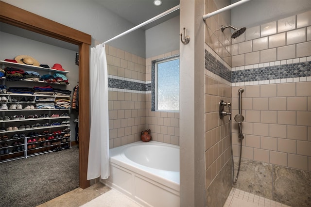 bathroom with a tile shower, a tub to relax in, and a spacious closet
