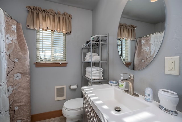 full bathroom featuring baseboards, toilet, and vanity