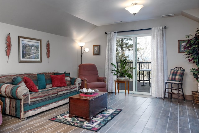 living area with wood finish floors, visible vents, and lofted ceiling