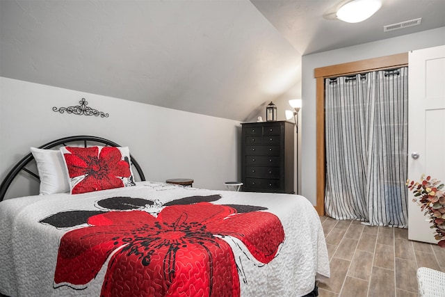 bedroom featuring lofted ceiling and wood finished floors