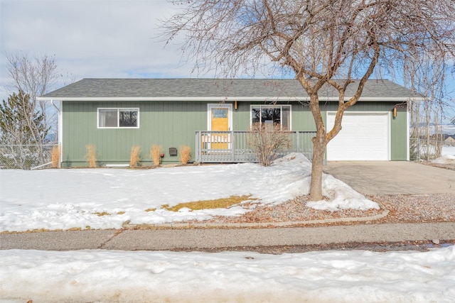 view of front facade with roof with shingles, a porch, an attached garage, fence, and driveway