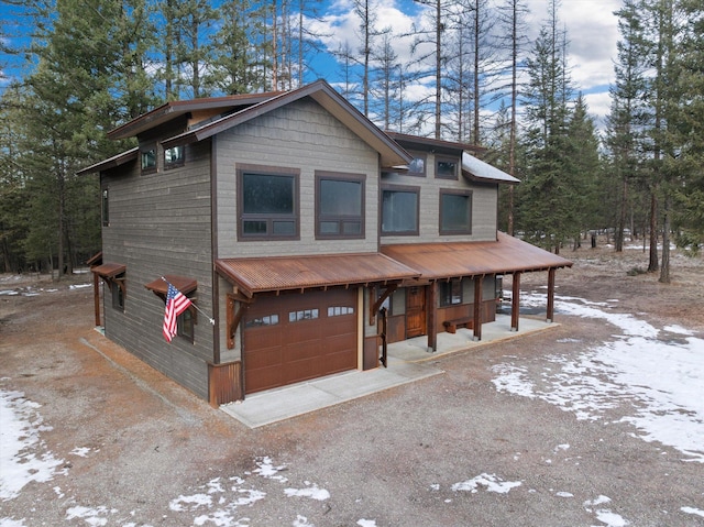 rustic home featuring a garage and dirt driveway