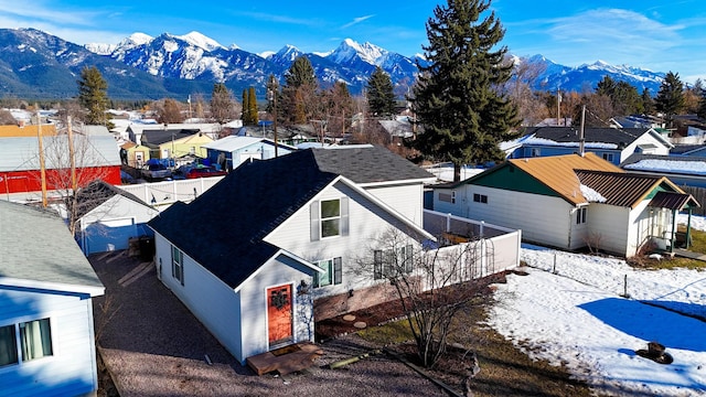 snowy aerial view featuring a residential view and a mountain view