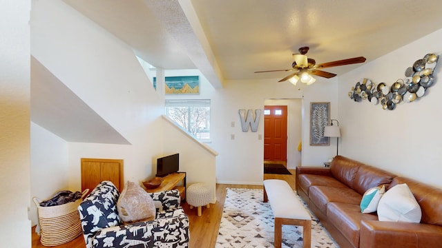 living room featuring a ceiling fan, baseboards, and wood finished floors