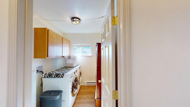 clothes washing area with light wood-type flooring, baseboard heating, cabinet space, and washing machine and clothes dryer