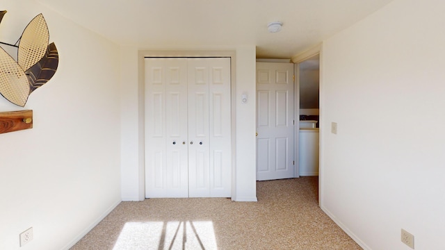 unfurnished bedroom featuring a closet, baseboards, and carpet flooring