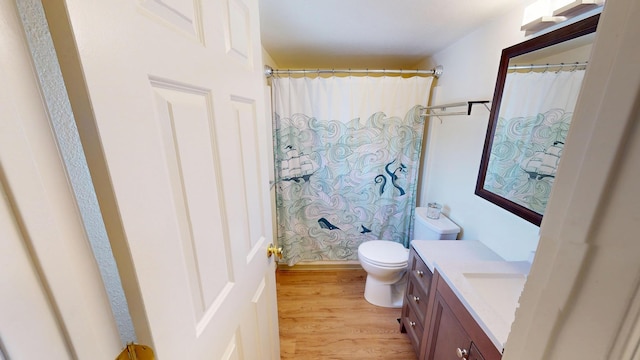 full bathroom featuring toilet, curtained shower, wood finished floors, and vanity