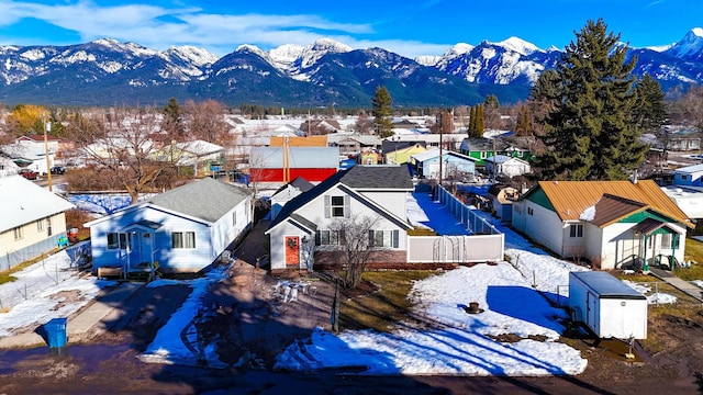 snowy aerial view with a residential view and a mountain view