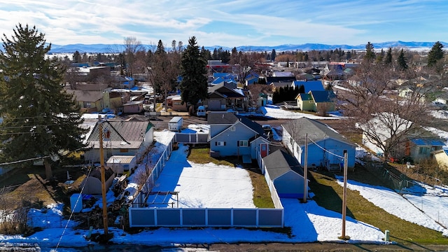 snowy aerial view with a residential view and a mountain view