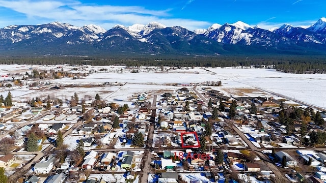 snowy aerial view with a residential view and a mountain view