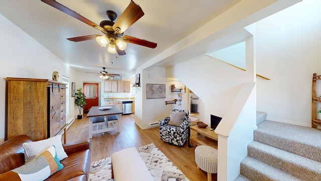 living room with light wood finished floors, stairs, baseboards, and a baseboard heating unit