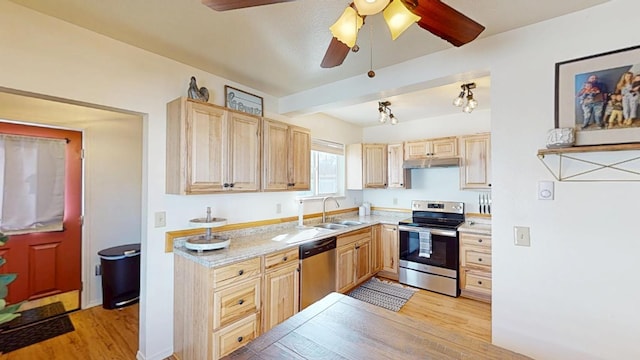 kitchen with under cabinet range hood, stainless steel appliances, light countertops, light wood-type flooring, and light brown cabinetry