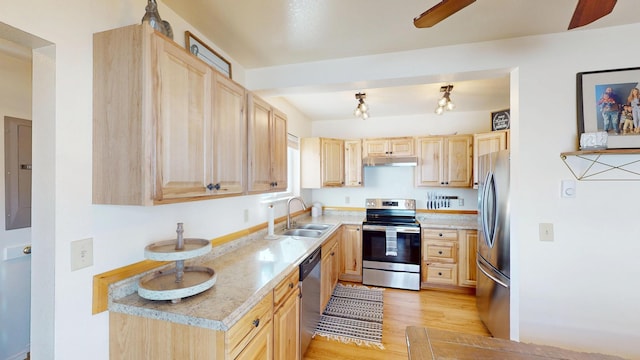 kitchen featuring stainless steel appliances, light countertops, light brown cabinets, and a sink