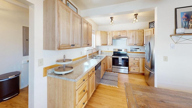 kitchen featuring light brown cabinets, under cabinet range hood, stainless steel appliances, a sink, and light countertops