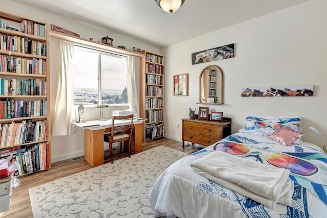 bedroom featuring wood finished floors and baseboards