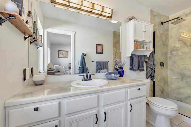 bathroom with toilet, a stall shower, and vanity