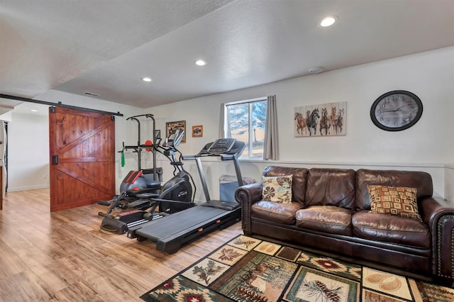 workout area featuring a barn door, recessed lighting, wood finished floors, visible vents, and baseboards