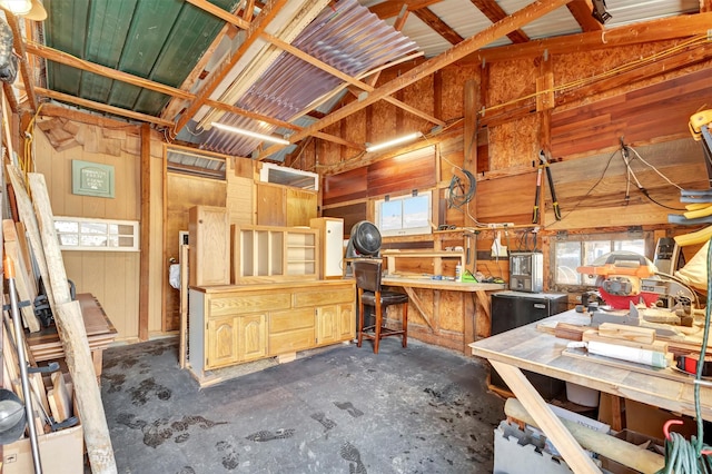 miscellaneous room featuring a workshop area and unfinished concrete flooring