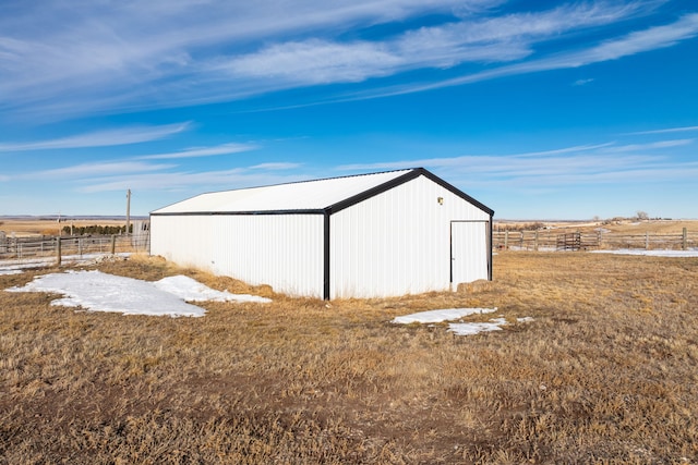 view of pole building featuring fence and a rural view