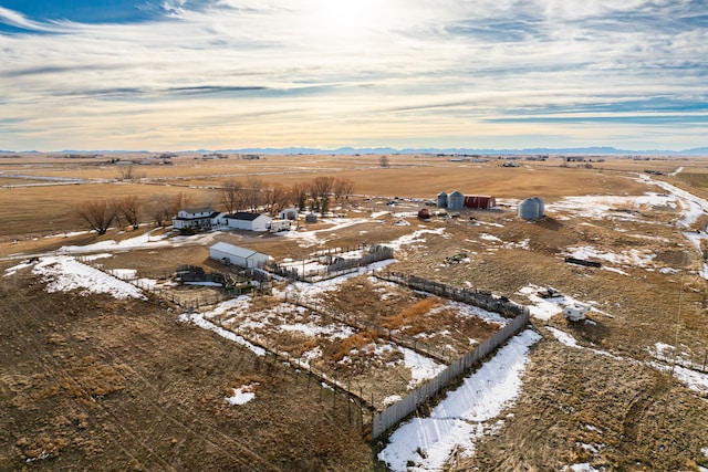 snowy aerial view featuring a rural view and a mountain view