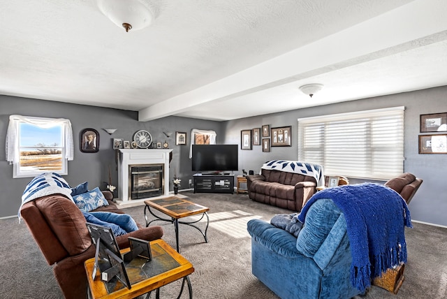 living area with carpet, beam ceiling, a glass covered fireplace, a textured ceiling, and baseboards