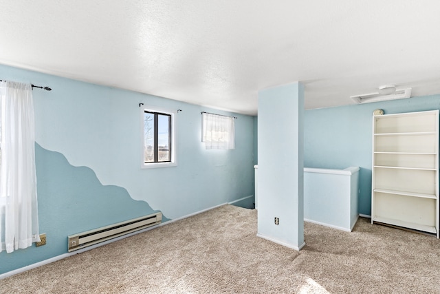 below grade area featuring a baseboard heating unit and carpet floors