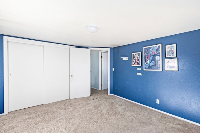 unfurnished bedroom with carpet floors and a closet