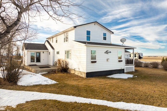 rear view of property featuring a lawn