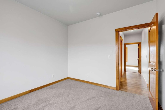 carpeted spare room featuring baseboards