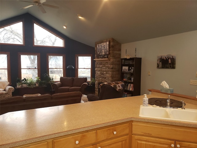 kitchen with vaulted ceiling, open floor plan, a sink, and light countertops