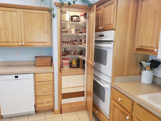 kitchen featuring light tile patterned floors, light countertops, and white appliances