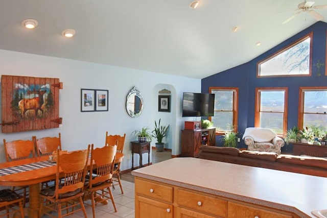 dining room with light tile patterned flooring, a ceiling fan, and vaulted ceiling