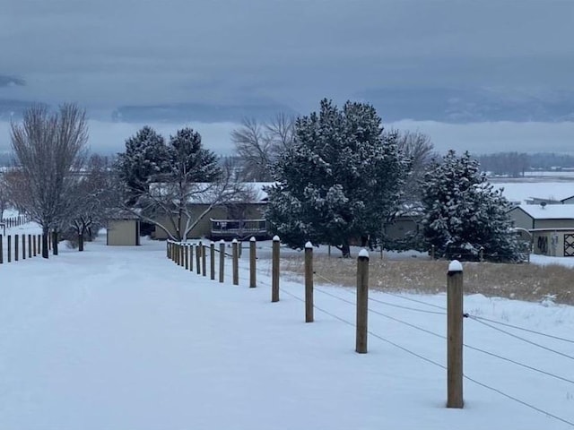 yard layered in snow featuring fence