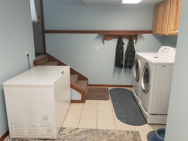 laundry room with washer and dryer, cabinet space, and light tile patterned floors