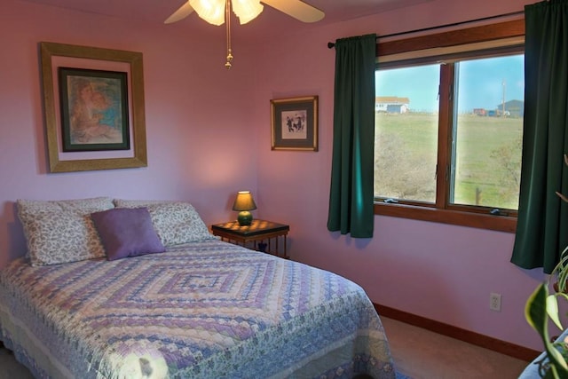 carpeted bedroom with a ceiling fan and baseboards