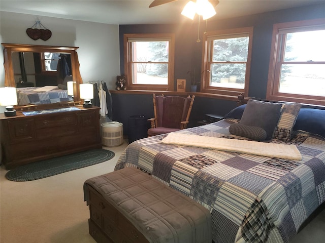 carpeted bedroom with ceiling fan and multiple windows