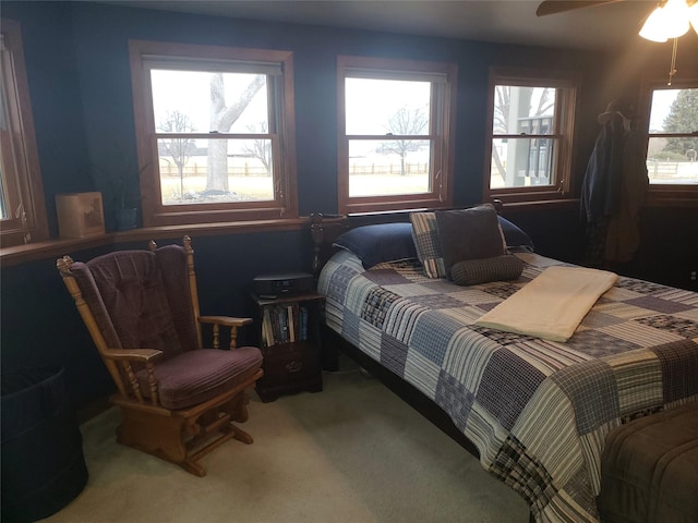 carpeted bedroom with multiple windows and a ceiling fan