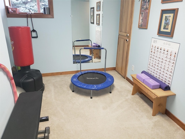 exercise area with light carpet and baseboards