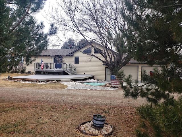 back of house with a deck and an attached garage