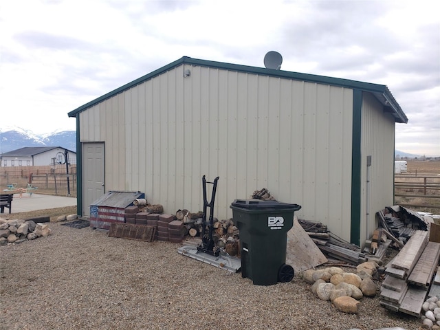 view of outbuilding with an outbuilding, fence, and a mountain view